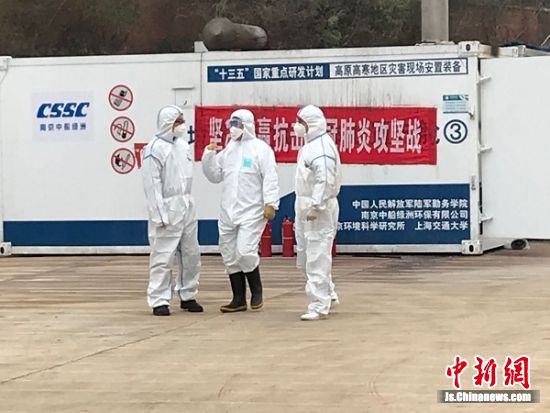 在移動(dòng)式醫(yī)療垃圾焚燒方艙前的工作人員
